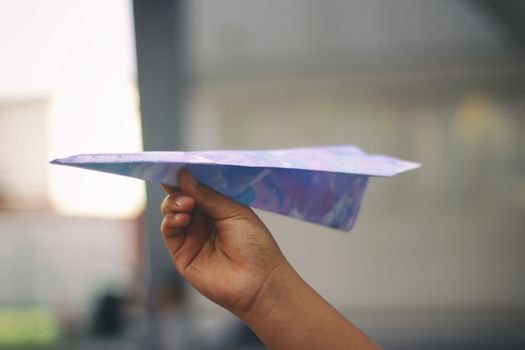 Photograph of a human hand with a paper plane