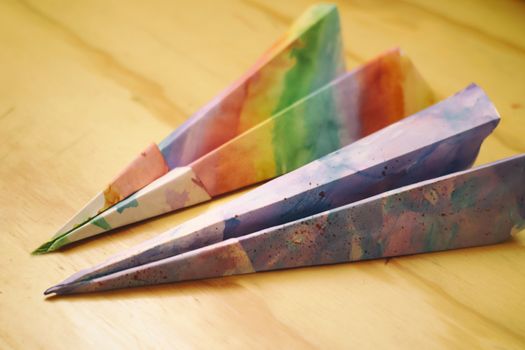 Photograph of some paper colorful planes on a wood table