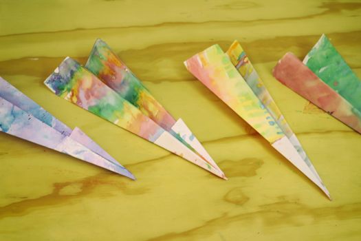 Photograph of some paper colorful planes on a wood table