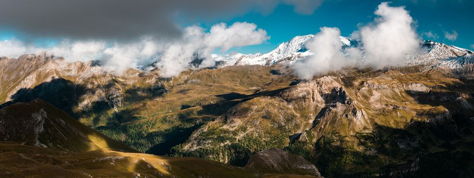 Dramatic Landscape in Austria Alps. Wide Panoramic Image. Mountains Peaks with Snow and Storm Clouds.