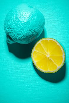 Whole Lemon Fruit and Lemon Slice on Blue Background. Modern Minimal Food Background.