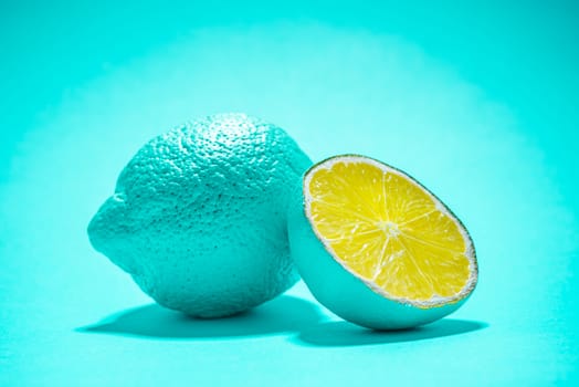 Whole Lemon Fruit and Lemon Slice on Blue Background. Modern Minimal Food Background.