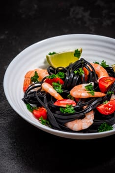 Squid Ink Pasta with Prawns , Tomatoes, Lemon and Herbs. Black Spaghetti, Black Organic Noodles . Mediterranean Gourmet Food.
