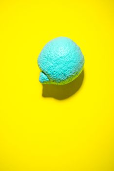 Abstract Blue Lemon Fruit on Vibrant Yellow Background. Modern Food Background.