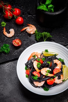 Squid Ink Pasta With Seafood, Herbs, Cherry Tomatoes. Black Spaghetti, Black Organic Noodles with Shrimps. Mediterranean gourmet food.