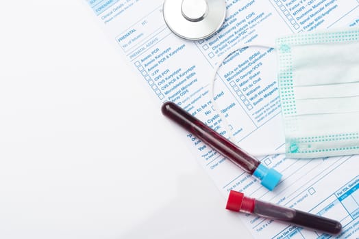 Laboratory Testing Patient’s Blood Samples for Presence of Coronavirus (COVID-19).  Test Tube Containing a Blood Sample on Doctor Table.