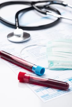 Laboratory Testing Patient’s Blood Samples for Presence of Coronavirus (COVID-19).  Test Tube Containing a Blood Sample on Doctor Table.