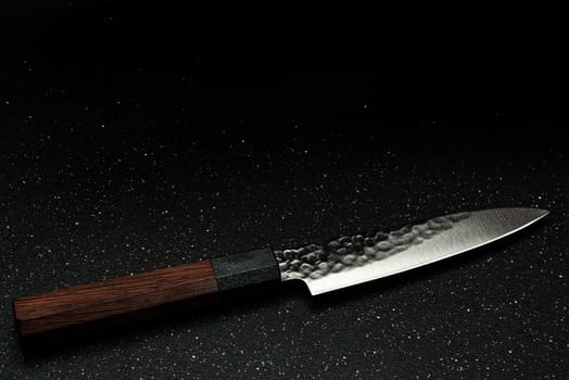 Handmade Professional Chef Knife on Black Board. Copy Space Background.