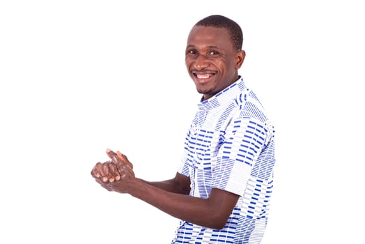 young man washing his hands thoroughly with antibacterial gel while smiling at the camera.