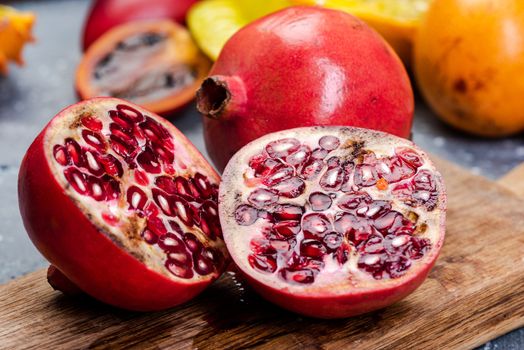 Pomegranate Tropical Fruit Cut in Half on Wooden Board.