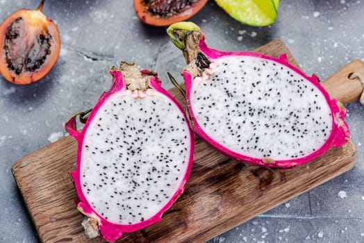 Pitahaya or Dragon Fruit Cut in Half on Board. Fresh Raw Exotic Fruits.