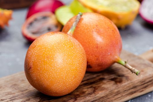 Granadilla or Grenadia Passionfruit Whole EXotic Fruits on Wooden Board.