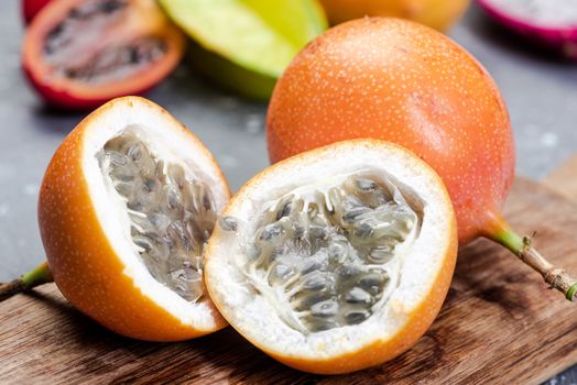 Granadilla or Grenadia Passionfruit Cut in Half Exotic Fruits on Wooden Board.