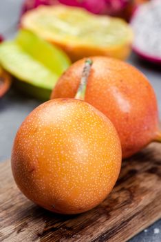 Granadilla or Grenadia Passionfruit Whole EXotic Fruits on Wooden Board.