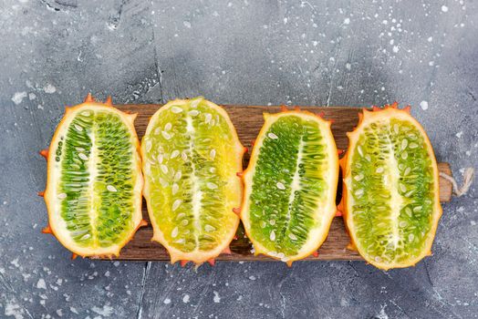 Kiwano or Horned Melon Exotic Fruits Cut in Half on Board. Copy Space. Top View.