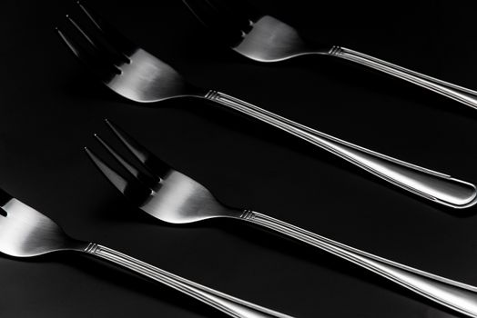 Silver Forks in Row on Dark Background. Low Kay Noir Image. Still Life Pattern Background.