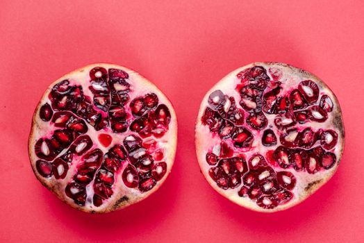 Pomegranate Fruit Two Halves Top Down View on Reg Background.