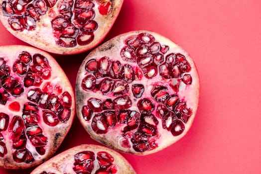 Pomegranate Fruit Halves on Reg Background. Top Down Flat Lay with Copy Space.