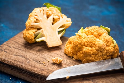 Yellow Cauliflower Cabbage on Cutting Board. Market Fresh Organic Food. Plant Based Diet.