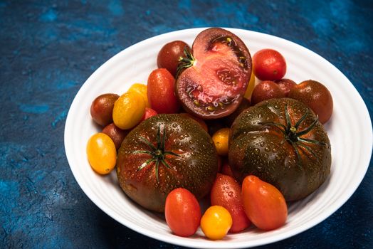 Vibrant Organic Tomatoes on Plate. Market Fresh Vegan Food. Plant Food Diet.