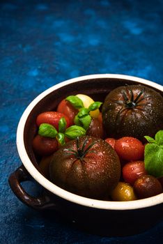 Market Fresh Organic Tomatoes on Concrete Kitchen Table Top.