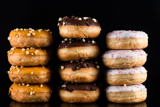 Donuts or Doughnuts Tower on Dark Background. Donut Stack Pile Food Background.
