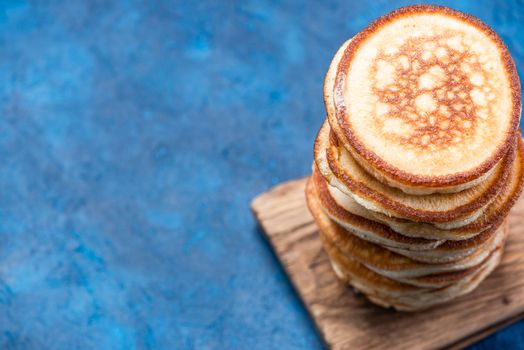 Stack of Pancakes on Wooden Board. Overhead View. Border Background.