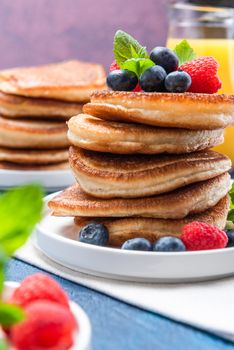 American Pancakes Served with Fresh Berry Fruits and Honey. Shrove Tuesday.