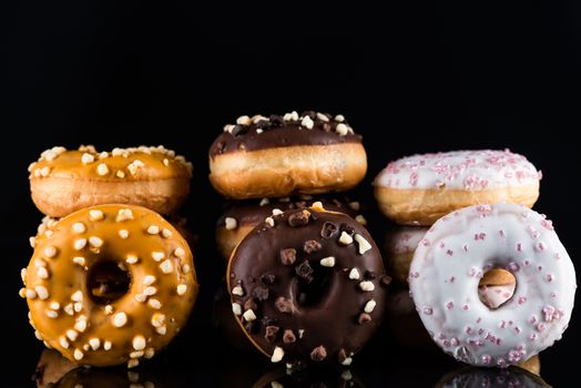 Donuts or Doughnuts Tower on Dark Background. Donut Stack Pile Food Background.