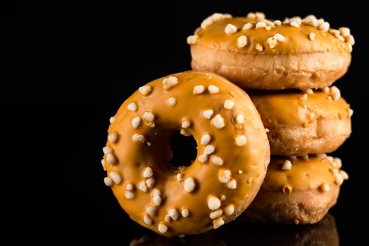 Stack of  Salted Caramel Donuts or Doughnuts on Black Background with Copy Space.