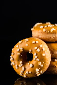 Salted Caramel Donuts or Doughnuts Tower on Dark Background. Copy Space for Text.