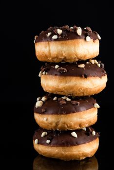 Chocolate Donuts or Doughnuts Tower on Dark Background. Copy Space for Text.