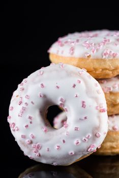 White Chocolate Donuts or Doughnuts Tower on Dark Background. Copy Space for Text.