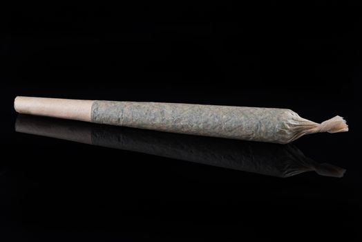 MEdical Marijuana Rolled Up Joint on Dark Background with Reflection.