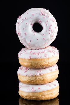White Chocolate  Donuts or Doughnuts Tower on Dark Background. Copy Space for Text