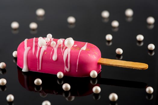 Pink Chocolate Popsicle on Dark Reflective Background. Creative Party Food.