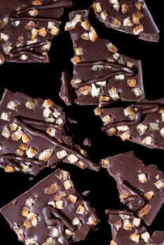 Broken Pieces of Chocolate Bar on Dark Background. Close Up View.