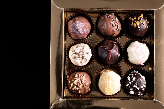 Box with Chocolate Pralines on dark Background. Copy Space.