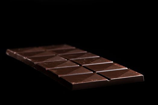 Chocolate Whole Bar on Black Background. Closeup View.