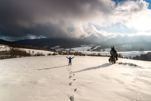 Active Man Standing at Snowy Mountain at Sunrise in Bieszczady, Poland.