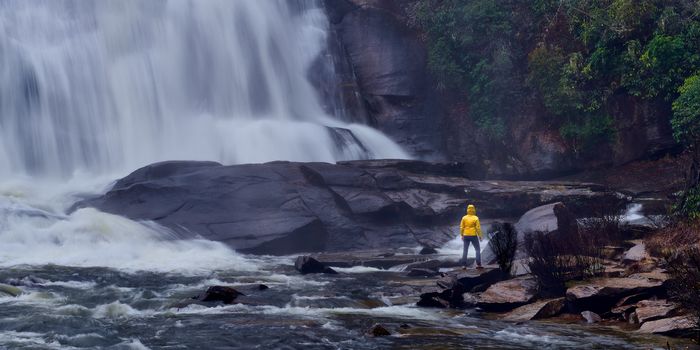 Woman standing at the base of High Falls at Dupont Forest, North Carolina.