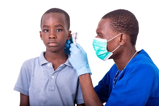 young pediatrician doctor using an examining the ear of a little boy in the hospital.