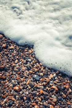 Sea water foam on the beach stones. Nautical marine summer background. Alanya. Turkey.
