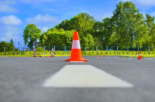 Red rubber cone in road construction. Road works, parking area.Traffic cone on the airport runway. Cone fence posts on the road for car driving training at the driver training school.