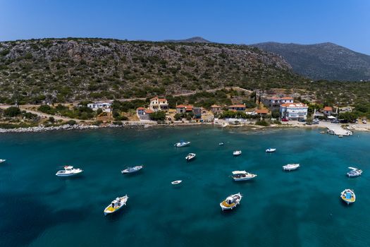 Aerial photo view of small traditional fishing boats in tropical emerald and turquoise clear sea. Peloponnese, Greece