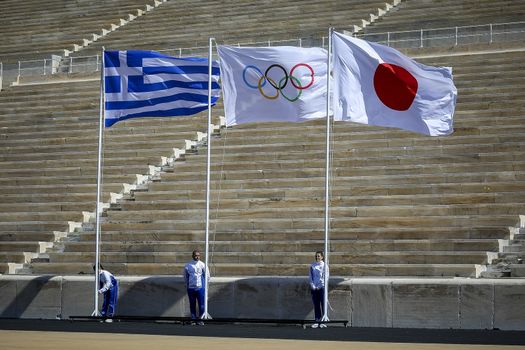 Athens, Greece - March 19, 2020: Olympic Flame handover ceremony for the Tokyo 2020 Summer Olympic Games at the Panathenaic Kallimarmaro Stadium. Olympics Flag