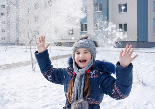 girl playing in the snow outside closeup