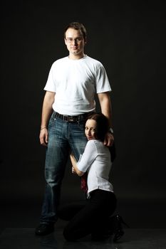 young family posing standing in studio on black background