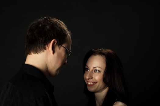 portrait of young couple in studio on black background