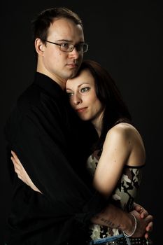 portrait of young happy couple in studio on black background
